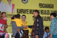 Foto: Penjabat Bupati Sikka Mekeng P. Florianus menyalami anak yang baru mendapatkan suntikan imunisasi campak dan rubella di Aula Santa Theresia Avila Maumere, Kamis (2/8)