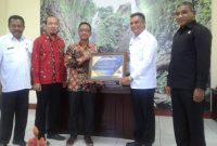 Pelaksana Tugas Kepala Kantor Wilayah Ditjen Perbendaharaan Provinsi NTT Agus Mirsatya menyerahkan piagam penghargaan kepada Bupati Sikka Fransiskus Roberto Diogo atas keberhasilan Pemkab Sikka menyusun dan menyajikan laporan keuangan tahun 2017 dengan capaian opini wajar tanpa pengecualian