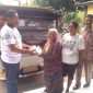 Kepala Desa Wairblerer Fransiskus Bedi Bura Pagan menyerahkan bantuan kepada korban kebakaran Maria Waldina, disaksikan oleh anak mantu korban dan Ketua KLPAMF Bona K. Kornelis, di Aula Kantor Desa Waiblerer, Jumat (16/11)