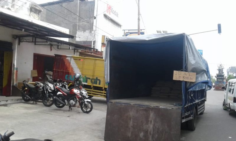 Salah satu truk melintasi jalan di Kota Maumere dengan membawa puluhan semen untuk dijual