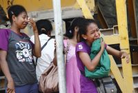 Yustin Berek Mulan (depan) sedang menangis histeris melihat jasad adiknya Damianus Ola Lewar yang mengalami kecelakaan kerja di PT Waigete Abadi, Sabtu (8/12)