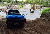 Kendaraan-kendaraan yang terperangkap akibat jembatan putus akhirnya bisa dievakuasi melewati Kali Dagemage, Jumat (18/1)