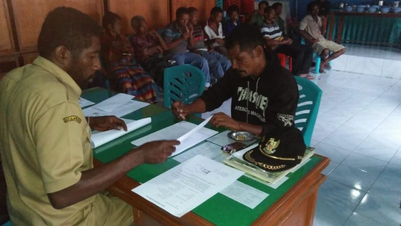 Januarius Joni pemilik lahan tanah longsor sedang menandatangani surat pernyataan damai dan surat kesepakatan bersama di depan Kepala Desa Hale Albertus Ruben, Jumat (1/2) di Kantor Desa Hale