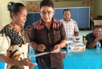 Anggota DPR RI andreas Hugo Pareira sedang memberikan sertifikat kepada orang tua penerima Program Indonesia Pintar di Aula SMAN 2 Maumere, Sabtu (23/2)