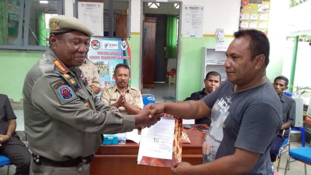 Kepala Kesatuan Polisi Pamong Praja dan Damkar Yoseph Benyamin menyerahkan berita acara penyelesaian masalah tanah Puskesmas Lekebai kepada salah satu ahli waris, Senin (28/1)