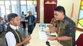 Anggota Komisi I DPR RI andreas Hugo Pareira sedang menyerahkan beasiswa Program Indonesia Pintar kepada salah satu siswa