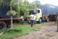 Sebuah truk berupaya mengeluarkan truk pengangkut suara suara yang terperosok ke dalam lumpur di halaman Kantor KPU Sikka, Jumat (15/3)