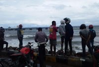 Sejumlah warga menyaksikan gelombang laut di pantai Pelabuhan Feri Kewapante yang menelan dua orang korban, Kamis (7/3)