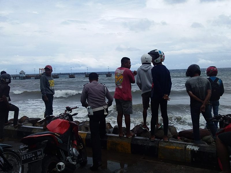 Sejumlah warga menyaksikan gelombang laut di pantai Pelabuhan Feri Kewapante yang menelan dua orang korban, Kamis (7/3)
