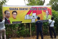 Petugas Panwascam Alok menurunkan baliho calon presiden di Jalan Lingkar Luar  Kelurahan Nangalimang, Senin (15/4)