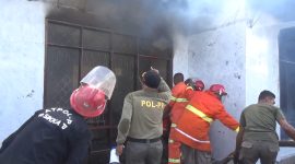 Petugas pemadam kebakaran sedang berupaya memadamkan kebakaran rumah di Kelurahan Waioti, Jumat (24/5)