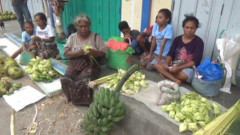 Pedagang di Pasar Alok Maumere sedang menganyam pucuk daun kelapa menjadi bungkusan ketupat, Selasa (4/6)