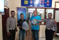 Kasatlantas Polres Sikka (paling kanan) memberikan helmn gratis kepada 2 orang pemohon SIM C