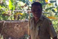 Kepala Desa Nele Barat Paulus Alus sedang menunjuk salah satu bak penampung air yang sudah penuh dengan lumut, Senin (29/7)