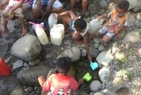 Anak-anak kecil di Desa Bhera Kecamatan Mego mengambil air  kubangan di bantaran sungai, Jumat (26/7)