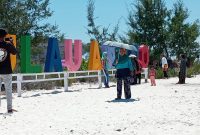 Pengunjung berfoto di depan tulisan Pulau Anano