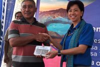 Direktur Teknologi PT XL Yessy D Yosetya memberikan handphone kepada nelayan Desa Aewora, Senin (28/10)