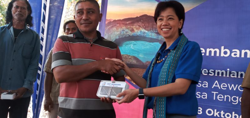 Direktur Teknologi PT XL Yessy D Yosetya memberikan handphone kepada nelayan Desa Aewora, Senin (28/10)