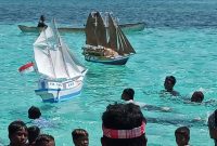 Miniatur kapal yang dihanyutkan ke laut lepas