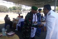 Bupati Sikka menyerahkan tumpeng kepada prajurit termuda TNI-AD, Sabtu (5/10) di Lapangan Umum Kota Baru Maumere