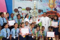 Kepala SMPK Frater Maumere menyerahkan piala bergilir kepada Kepala SDK Bhaktyarsa Maumere, Jumat (8/11) malam di Aula Mardiwiyata Maumere