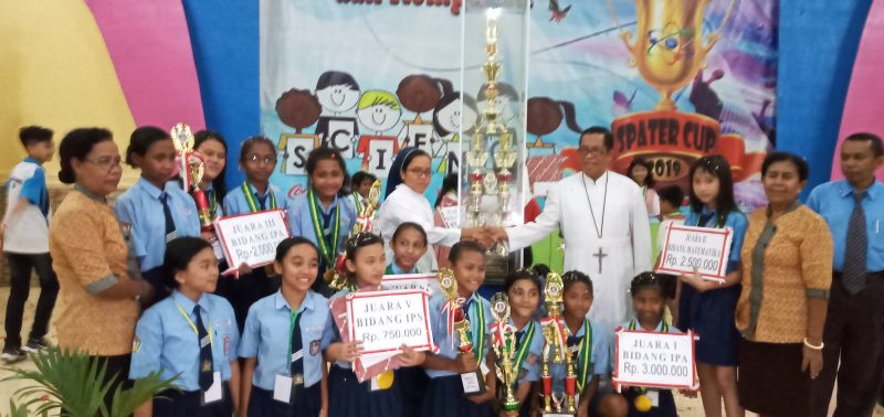 Kepala SMPK Frater Maumere menyerahkan piala bergilir kepada Kepala SDK Bhaktyarsa Maumere, Jumat (8/11) malam di Aula Mardiwiyata Maumere