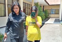 Tersangka kepemilikan sabu-sabu, EW alias E sedang dikawal seorang polisi wanita di Mapolres Sikka
