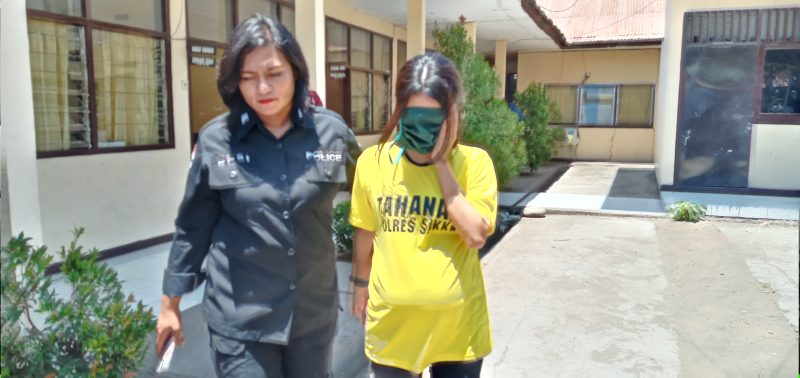 Tersangka kepemilikan sabu-sabu, EW alias E sedang dikawal seorang polisi wanita di Mapolres Sikka