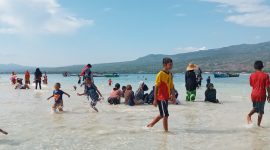 Pengunjung menikmati daratan di laut lepas pada Taka Embo Mina di perairan Laut Flores, Selasa (31/12)