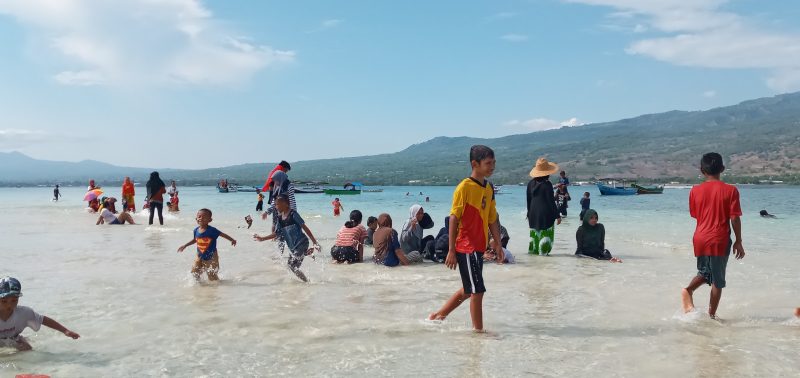 Pengunjung menikmati daratan di laut lepas pada Taka Embo Mina di perairan Laut Flores, Selasa (31/12)