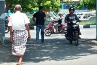 Kakek terduga pelaku berjalan keluar dari halaman Mapolres Sikka, Kamis (13/2)