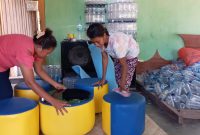 Maria Angelina Deya (baju merah) sedang mengerjakan sofa dari botol bekas air mineral, Senin (24/2)