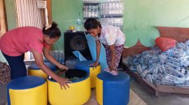 Maria Angelina Deya (baju merah) sedang mengerjakan sofa dari botol bekas air mineral, Senin (24/2)