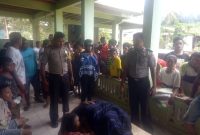 Korban kebakaran (ditutup dengan kain sarung) dibaringkan di teras rumah tetangga, Sabtu (8/2)