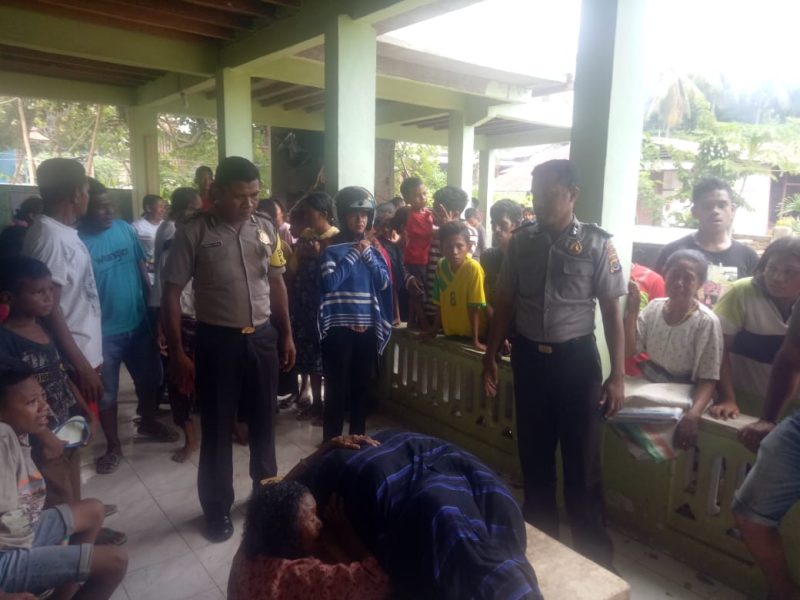 Korban kebakaran (ditutup dengan kain sarung) dibaringkan di teras rumah tetangga, Sabtu (8/2)