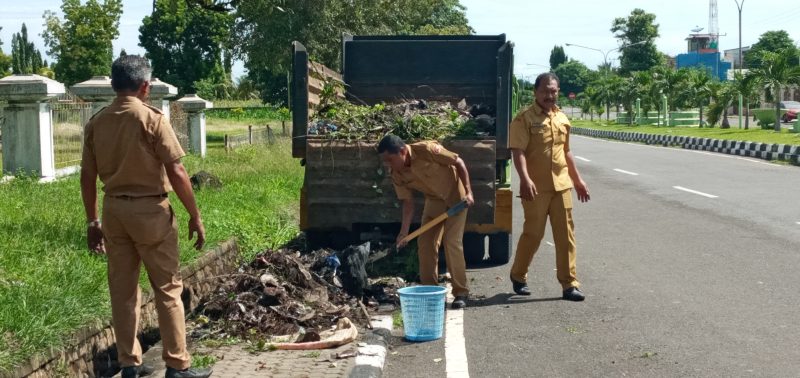 Kabag Organisasi Setda Sikka dan staf sedang mengangkut sampah di depan Kantor Bupati Sikka, Senin (9/3)