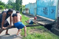 Warga Wairotang bongkar plat deker, Rabu (11/3), agar ada akses membersihkan sampah yang tertumpuk di dalam drainase