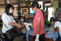 Petugas kesehatan menyemprotkan cairan antiseptik ke tangan seorang penumpang yang baru tiba di Bandara Frans Seda Maumere, Minggu (22/3)