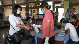 Petugas kesehatan menyemprotkan cairan antiseptik ke tangan seorang penumpang yang baru tiba di Bandara Frans Seda Maumere, Minggu (22/3)