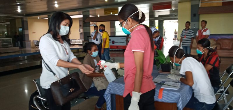 Petugas kesehatan menyemprotkan cairan antiseptik ke tangan seorang penumpang yang baru tiba di Bandara Frans Seda Maumere, Minggu (22/3)