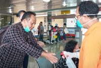 Petugas menyemprotkan cairan antiseptik kepada penumpang yang baru tiba di Bandara Frans Seda Maumere, Minggu (22/3)