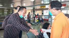 Petugas menyemprotkan cairan antiseptik kepada penumpang yang baru tiba di Bandara Frans Seda Maumere, Minggu (22/3)