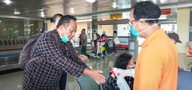Petugas menyemprotkan cairan antiseptik kepada penumpang yang baru tiba di Bandara Frans Seda Maumere, Minggu (22/3)
