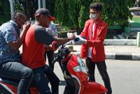 Ketua GMNI Sikka sedang membagikan masker gratis kepada pelintas jalan di Jalan Ahmas Yani Maumere, Senin (23/3)