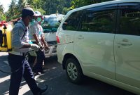 Petugas Dishub Sikka sedang menyemprot cairan disinfektan ke mobil yang melintasi perbatasan Kabupaten Sikka dan Kabupaten Ende, Senin (30/3)
