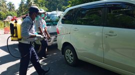 Petugas Dishub Sikka sedang menyemprot cairan disinfektan ke mobil yang melintasi perbatasan Kabupaten Sikka dan Kabupaten Ende, Senin (30/3)
