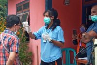 Pemeriksaan suhu tubuh salah satu pelintas jalan di Posko Pengamanan Perbatasan di Desa Hikong, Sabtu (4/4)