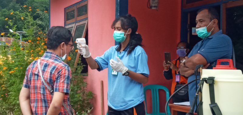 Pemeriksaan suhu tubuh salah satu pelintas jalan di Posko Pengamanan Perbatasan di Desa Hikong, Sabtu (4/4)