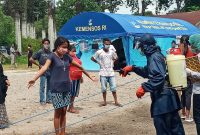 Suasana penyemprotan antiseptik kepada warga yang sedang menjalani karantina di Gedung SCC, Senin (13/4) pagi