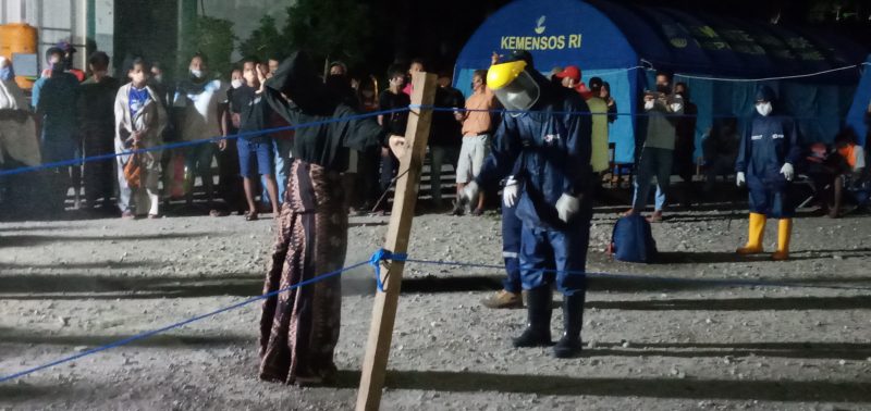 Orang terindikasi Covid 19 disemprot antiseptik, sebelum dibawa ke ruang isolasi, Kamis (23/4)